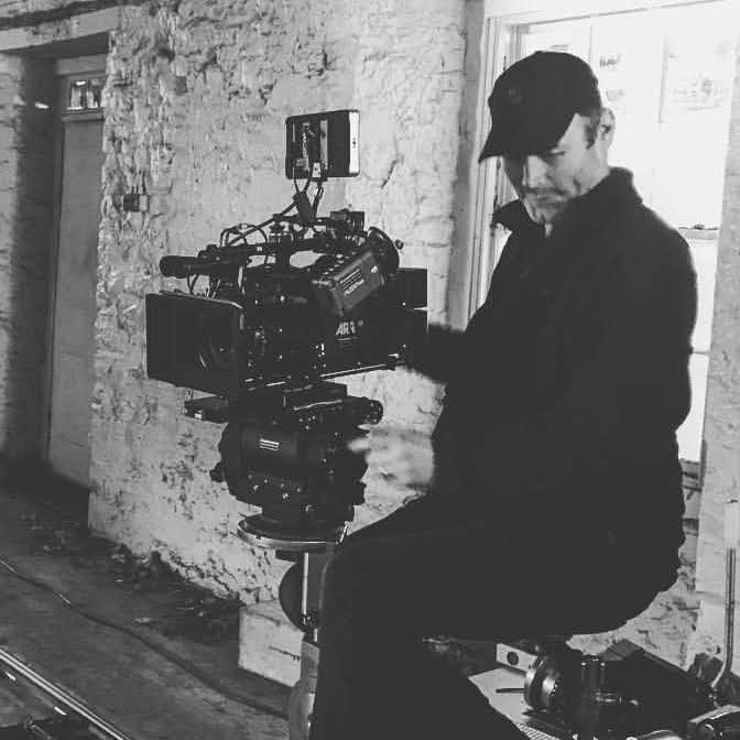 Andrew Begg operating an ARRI camera on a dolly in a whitewashed stone room